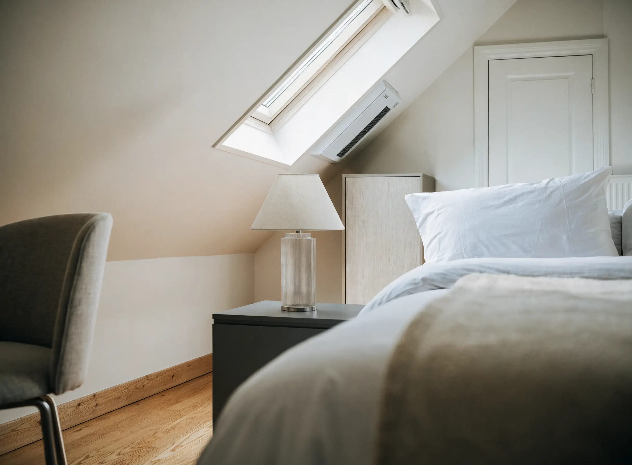 A loft bedroom shown in the Hush Climate concept, styled cool and calm