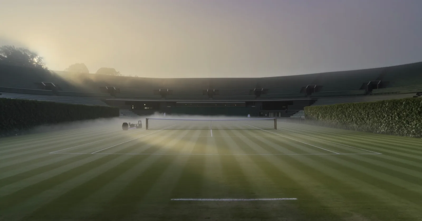 Empty tiered stands at dawn, mist over the grass
